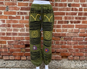 May include: Green pants with black stripes and yellow embroidery. The pants have a drawstring waist and a loose fit.