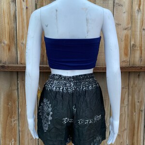 May include: A black and white patterned pair of shorts with a white waistband and white text. The shorts are paired with a solid blue tube top.