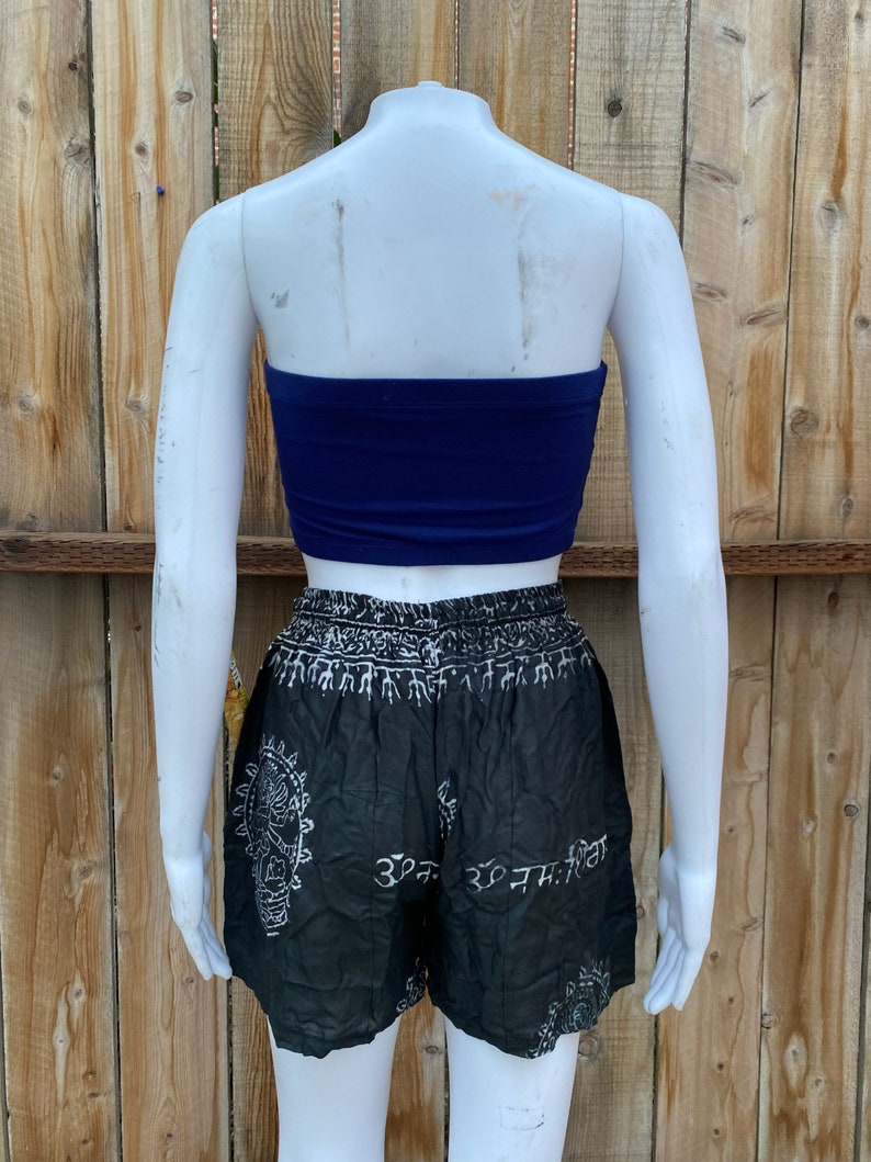 May include: A black and white patterned pair of shorts with a white waistband and white text. The shorts are paired with a solid blue tube top.