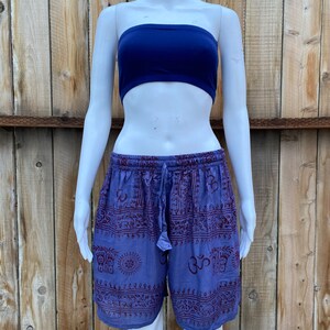May include: Purple and red patterned shorts with a drawstring waist. The pattern includes various symbols and designs.
