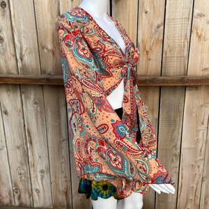 Boho hippie overslagtop met lange klokmouwen en stropdas aan de voorkant, kleurrijk paisley- en bloemenpatroon, festivalboho-feeëngodin, zomer uitgaan