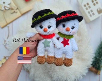 May include: Two handmade crochet snowmen with black hats, red and green scarves, and star accents. The snowmen have brown feet, orange noses, and blue eyes. The text "Pdf Pattern" is visible.