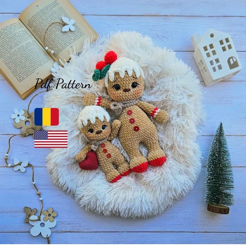 May include: Two crocheted gingerbread man dolls, one large and one small, rest on a fluffy white surface. The larger doll has a scarf, red buttons, and a decorative hat. The smaller doll holds a red heart. The text "Pdf Pattern" is visible.