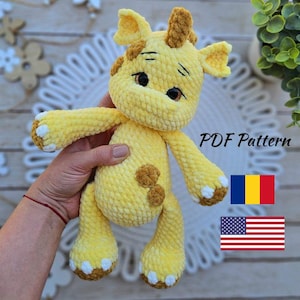 May include: A handmade yellow crochet giraffe with brown spots and accents. The giraffe has a friendly expression and is holding its arms out. The text "PDF Pattern" is visible. The image also includes the flags of Romania and the United States.