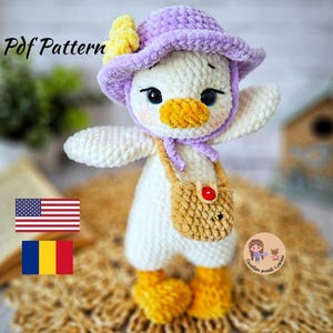 Op de afbeelding: Haak amigurumi patroon voor een witte eend met een paarse en gele hoed en een bruine tas. Het patroon is beschikbaar in het Engels en Roemeens.