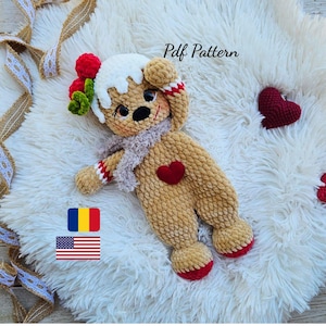 May include: A handmade, plush gingerbread man doll with a red heart, red accents, and a white icing design. The doll has a gray scarf and is lying on a fluffy white surface. The text "Pdf Pattern" is visible.