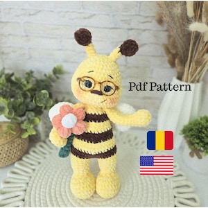Puede incluir: Muñeca de abeja de ganchillo amarilla y marrón hecha a mano, con gafas y una flor. La abeja tiene antenas y alas marrones. El texto "Pdf Pattern" es visible en la imagen.