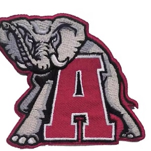 May include: Embroidered patch featuring a gray elephant and the letter "A" in crimson red. The elephant is detailed with gray and black stitching, and the letter "A" has a white outline. The patch has a crimson red border.