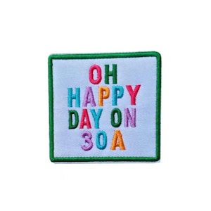 May include: Embroidered patch with the words "OH HAPPY DAY ON 30A" in colorful letters. The patch has a white background with a green border. The text is in various colors, including red, blue, green, orange, and purple.