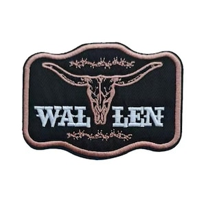 May include: Embroidered patch with a black background and a light brown bull skull design. The patch has a light brown border and the word "WAL LEN" in white letters.