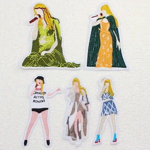 May include: Embroidered patches featuring stylized figures with microphones. The patches showcase various outfits in shades of green, orange, blue, and brown. One patch includes the text "ALGY JAHK OK ASTHE MOMENT".