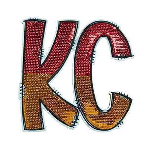 May include: A sequined patch featuring the letters "KC" in a bold, stylized font. The "K" is divided into red and gold sections, while the "C" is entirely red. The letters are outlined in black with white stitching.