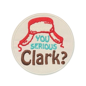 May include: Embroidered patch with a cream-colored background. The patch features a red winter hat design above the words "YOU SERIOUS Clark?" in teal and brown. The patch is round and has a stitched border.