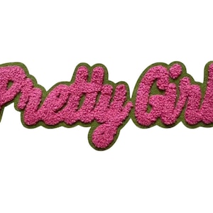 May include: A pink, textured patch with the words "Pretty Girl" in a cursive font. The lettering is outlined with a green border, creating a bold and eye-catching design. The patch is set against a white background.