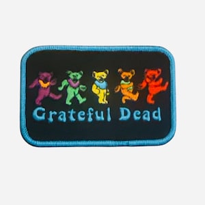 May include: Embroidered patch featuring five colorful dancing bears in purple, green, yellow, orange, and red. The patch has a black background with the words "Grateful Dead" in blue, and a blue border.