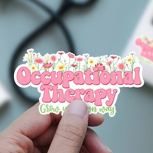 May include: Pink and white sticker with the text "Occupational Therapy" in a retro font. The text is surrounded by a border of pink flowers. The sticker also includes the text "Grow your own way".