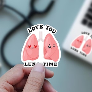 Pode incluir: Um adesivo rosa e branco com dois pulmões de desenho animado que dizem "Love you lung time".
