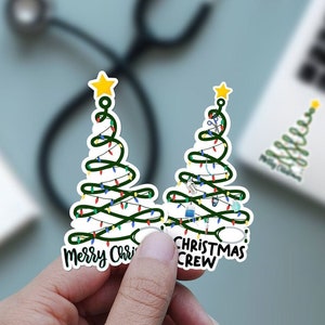 May include: Two Christmas tree stickers with medical symbols and the text "Merry Christmas Crew".