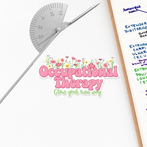 Pode incluir: Etiqueta rosa e verde com o texto "Occupational Therapy Grow your own way" e um design floral. A etiqueta est&aacute; sobre uma superf&iacute;cie branca ao lado de um transferidor e uma p&aacute;gina de desenhos anat&ocirc;micos.