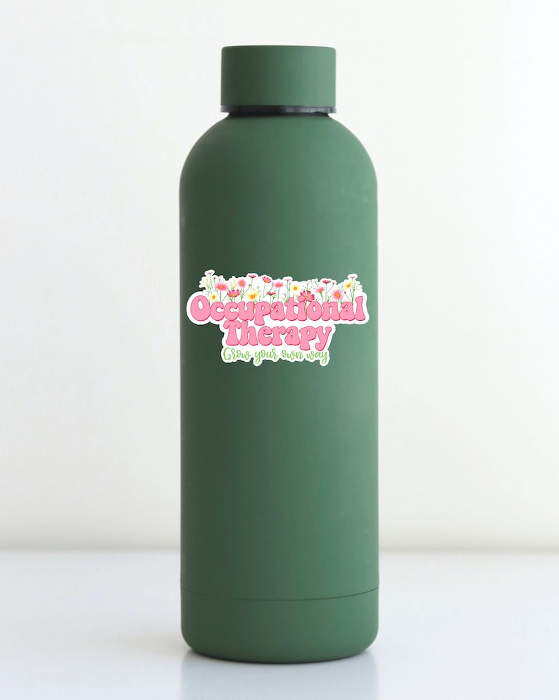 Pode incluir: Garrafa de &aacute;gua reutiliz&aacute;vel verde com um adesivo rosa e branco que diz "Occupational Therapy Grow your own way" com um design floral.