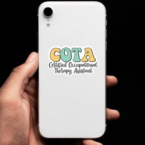 Pu&ograve; includere: Uno smartphone bianco con un adesivo che dice "COTA Certified Occupational Therapy Assistant". L'adesivo ha lettere gialle, verdi e blu.
