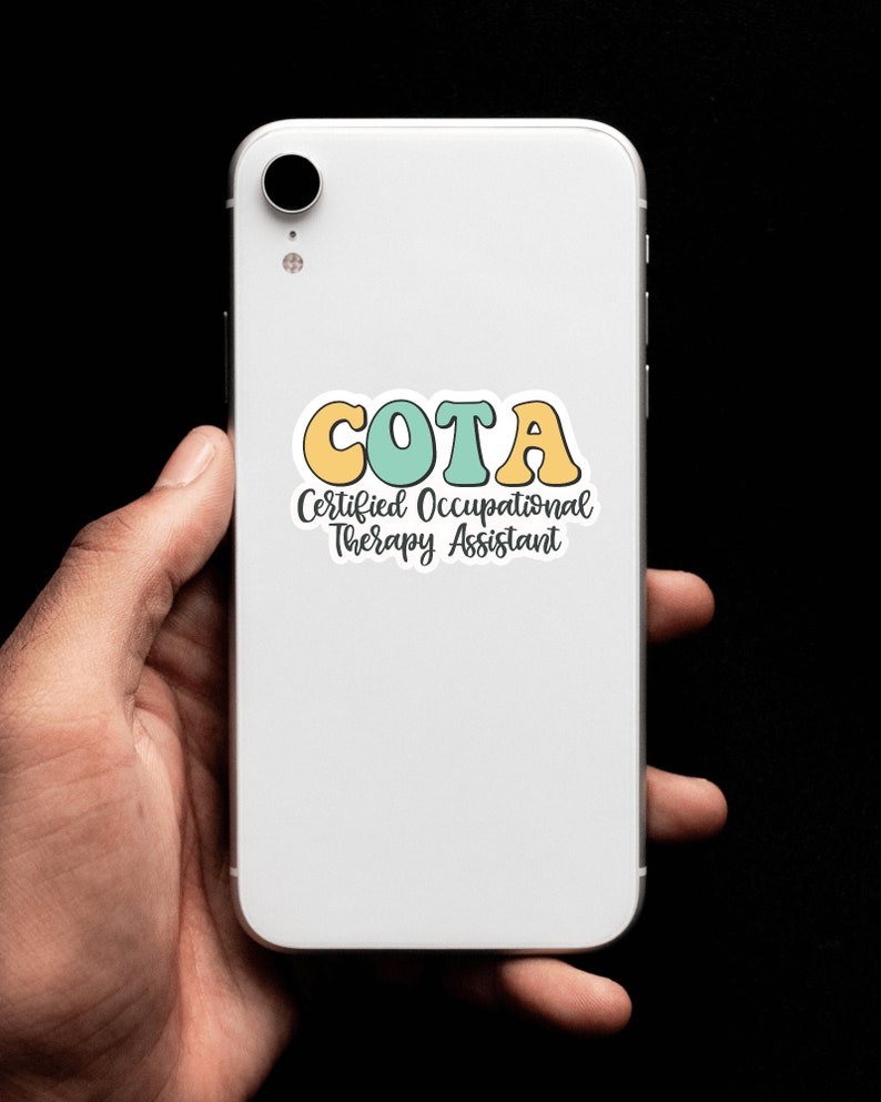 Pu&ograve; includere: Uno smartphone bianco con un adesivo che dice "COTA Certified Occupational Therapy Assistant". L'adesivo ha lettere gialle, verdi e blu.