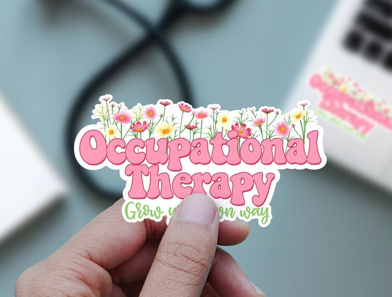 Pode incluir: Adesivo rosa e branco com o texto "Occupational Therapy" em uma fonte retr&ocirc;. O texto &eacute; cercado por uma borda de flores rosa. O adesivo tamb&eacute;m inclui o texto "Grow your own way".