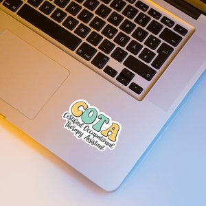 Pu&ograve; includere: Un adesivo con il testo "COTA Certified Occupational Therapy Assistant" in un font retr&ograve; colorato. L'adesivo &egrave; su un laptop argentato.