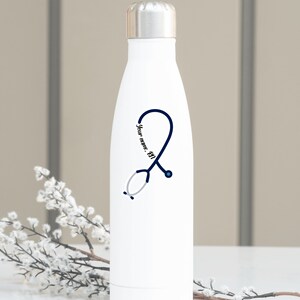 Puede incluir: Botella de agua de acero inoxidable blanca con un dise&ntilde;o de estetoscopio azul y el texto "Your name, RN".