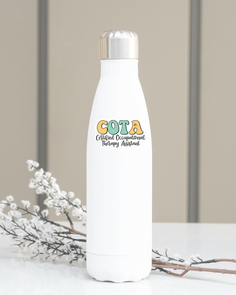 Pu&ograve; includere: Bottiglia d'acqua in acciaio inox bianca con una grafica colorata che dice "COTA Certified Occupational Therapy Assistant".