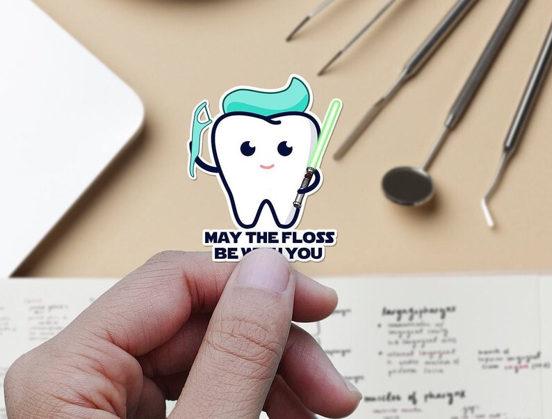 May include: A white cartoon tooth character holding a green lightsaber and a dental floss pick. The text reads "May the floss be with you".