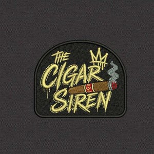 May include: A black embroidered patch featuring the yellow text The Cigar Siren, a yellow crown icon, and a brown cigar with a red band and grey smoke. The patch has a rounded top edge and a black border, set against a dark grey fabric background.