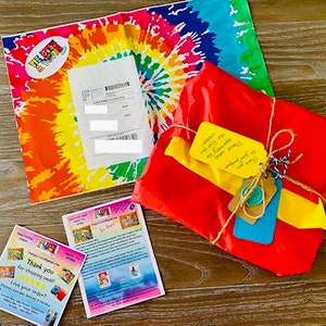 May include: A red, yellow, and blue gift wrapped in brown twine with a handwritten note that says "exception my very 1st gift from mommy!" and a tag that says "weekend trip so much fun!"