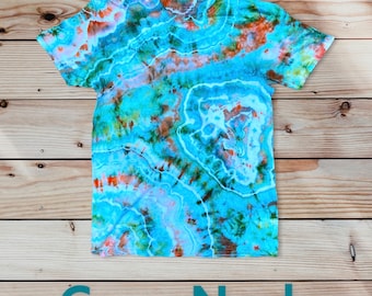 May include: A blue tie-dye t-shirt with orange, green, and white accents. The shirt has a crew neck and short sleeves.