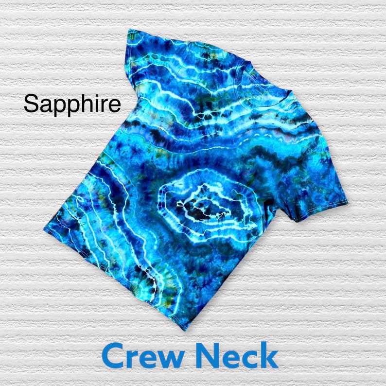 May include: A blue tie-dye t-shirt with a crew neck. The shirt has a swirling pattern of blue, green, and white.