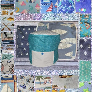 May include: A collection of fabric swatches with various nautical and aquatic-themed patterns. Designs include sailboats, mermaids, fish, anchors, and beach scenes. A central, turquoise fabric bin with a white pocket is also featured.