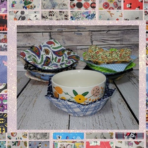 May include: A collection of fabric bowl cozies in various patterns, including paisley, floral, and polka dots. The cozies are designed to hold bowls and prevent burns. The image shows a white ceramic bowl with a floral design, resting in a blue plaid cozy.