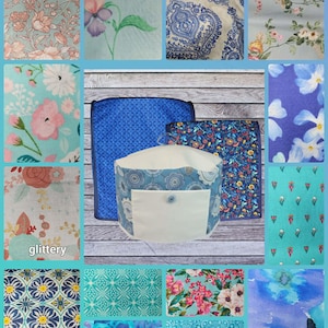 May include: A collection of fabric samples and a cylindrical container with a white pocket and button. The fabrics feature floral and geometric patterns in shades of blue, pink, and teal. The container is blue with a white pocket.