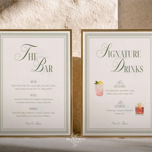 May include: Two framed signs with gold borders. The left sign reads "The Bar" in elegant script, listing beer, wine, and spirits. The right sign says "Signature Drinks" and features watercolor illustrations of cocktails, including a Gin Daisy and a Negroni.