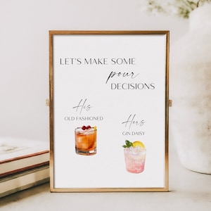 May include: A framed print with the text "LET'S MAKE SOME pour DECISIONS." Below, watercolor illustrations depict an Old Fashioned cocktail and a Gin Daisy. The frame is gold-colored.