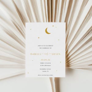 Op de afbeelding: Een witte huwelijksuitnodiging met gouden tekst en een maan- en sterrenontwerp. De uitnodiging bevat de namen Isabella en Steven, de datum 19.09.26, de tijd en de trouwlocatie in Austin, TX.