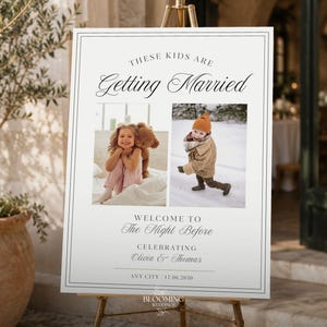 May include: A white rectangular wedding welcome sign on a gold easel featuring the text "THESE KIDS ARE Getting Married" and "WELCOME TO The Night Before" with two photos of children and the names "Olivia & Thomas" with the date "17.06.2030".