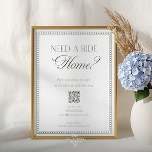 May include: A framed sign with the text "NEED A RIDE Home?" in elegant script. The sign includes a QR code and details about splitting an Uber. A vase with blue hydrangeas and dried grasses sits beside the sign.