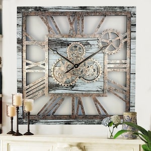 Puede incluir: Un reloj de pared grande, cuadrado y rústico con números romanos y un acabado de madera desgastada. La esfera del reloj presenta un diseño de engranaje con tres engranajes móviles.