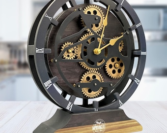 May include: Black and gold clock with a gear design. The clock face has Roman numerals and the base has the text "Improving Life" with a coffee bean logo.