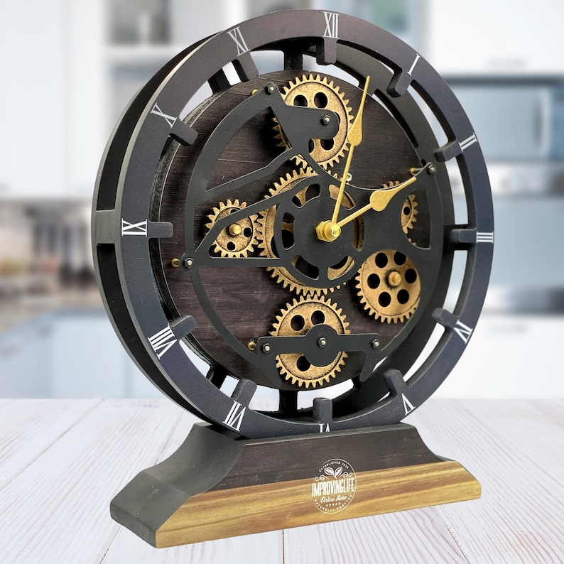 May include: Black and gold clock with a gear design. The clock face has Roman numerals and the base has the text "Improving Life" with a coffee bean logo.
