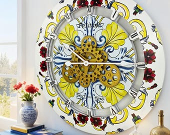 May include: A round wall clock featuring a white background with yellow and blue floral patterns and red accents. The center displays exposed gold-colored mechanical gears. The clock face includes black Roman numerals and the text Positano.