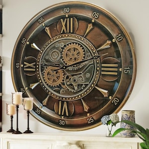 Könnte beinhalten: Eine große, runde Uhr im antiken Stil mit römischen Ziffern und einem Zahnrad-Design. Das Zifferblatt der Uhr ist braun mit goldenen Akzenten und die Zeiger sind schwarz. Die Uhr hängt an einer weißen Wand über einem Kamin.