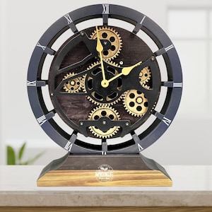 May include: A black and gold clock with a gear design. The clock has Roman numerals and is on a wooden base.