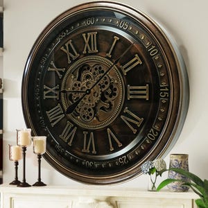 Puede incluir: Un reloj grande, redondo, de estilo antiguo con números romanos y un mecanismo de engranaje visible. La esfera del reloj es negra con detalles dorados y el marco es marrón.